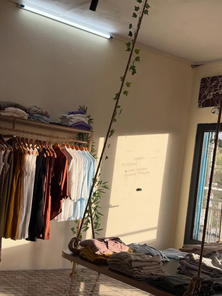 Sunlit boutique interior with linen garments and natural wood